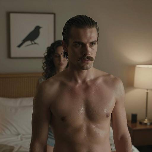 Shirtless Man in Dimly Lit Bedroom