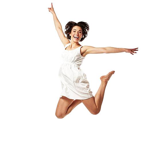 Photograph of a joyful woman with short black hair, wearing a white sleeveless dress, jumping with arms and legs outstretched against a white background