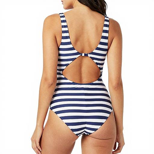 Photograph of a woman from behind wearing a navy and white striped, high-cut one-piece swimsuit with a keyhole back. White background.