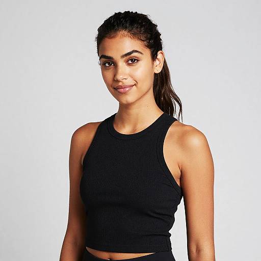 Photograph of a young woman with medium brown skin, dark brown eyes, and black hair in a ponytail, wearing a black ribbed crop tank