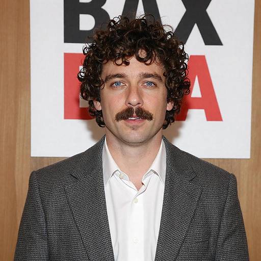 Man with Curly Hair and Mustache in Gray Jacket