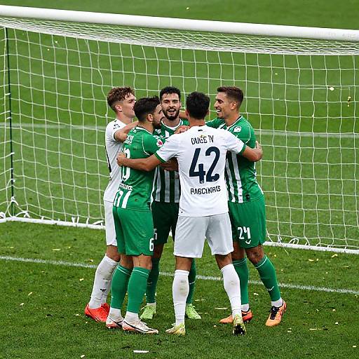 Photograph of four male soccer players, three in green jerseys, one in white with 