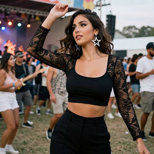 Photograph of a confident woman with medium tan skin, wavy dark hair, wearing a black lace crop top and high-waisted black pants,