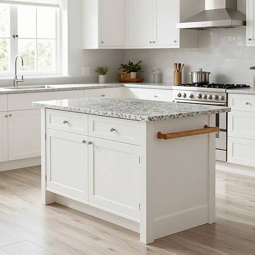 Photograph of a bright, modern kitchen featuring a white island with a marble countertop, stainless steel stove, white cabinets, and wooden handles. Natural