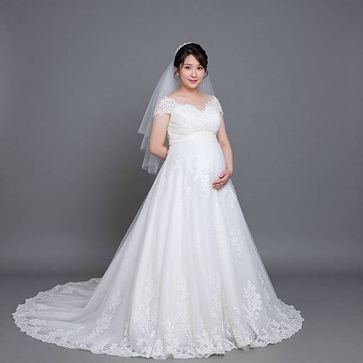 Photograph of an Asian bride with fair skin, black hair, wearing a white lace wedding dress and veil, standing against a gray background.
