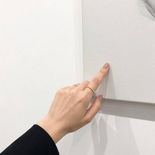 Elegant Hand with Ring Pointing at Canvas