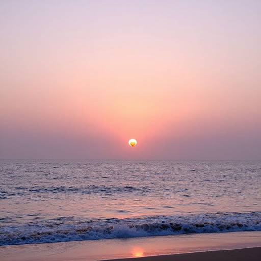 Photograph of a serene beach at sunset, with a pink and orange sky, a glowing sun on the horizon, gentle waves, and a reflective shoreline
