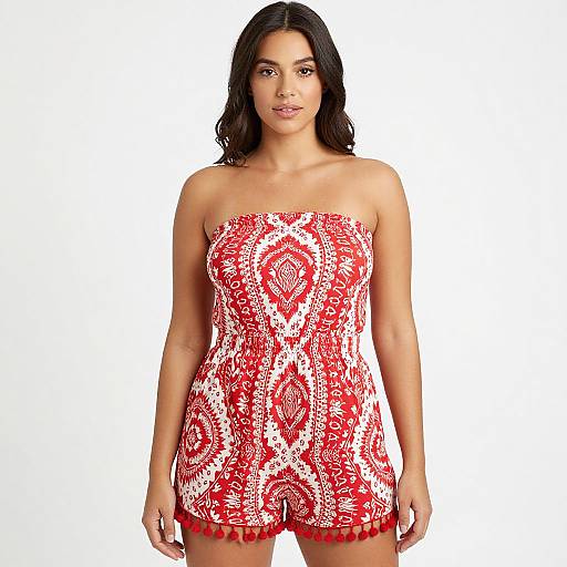 Photograph of a young woman with dark hair, wearing a strapless red and white patterned romper, standing against a plain white background.