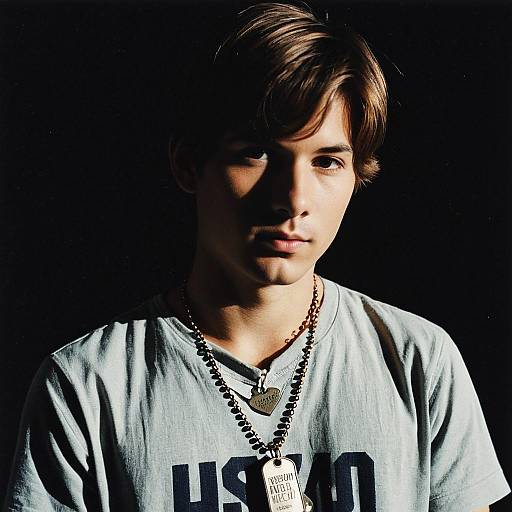 Young Man with Dog Tags and Necklace in Shadow