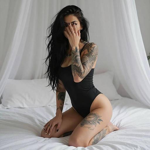 Tattooed Woman Crouching on Bed