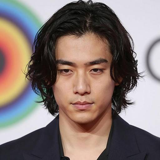 Young Asian man with wavy hair and dark shirt