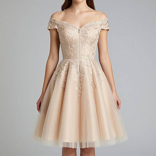 Photograph of a woman in an off-the-shoulder, cream-colored lace and tulle knee-length dress with a fitted bodice and flared