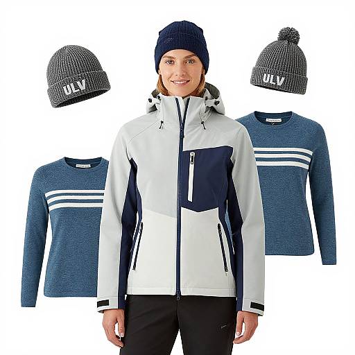 Photograph of a smiling woman in white and navy jacket, black pants, and navy beanie, surrounded by two navy sweaters and two beanie