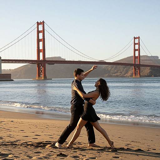 Photograph of a dancing couple in black outfits on a sandy beach with the Golden Gate Bridge in the background.