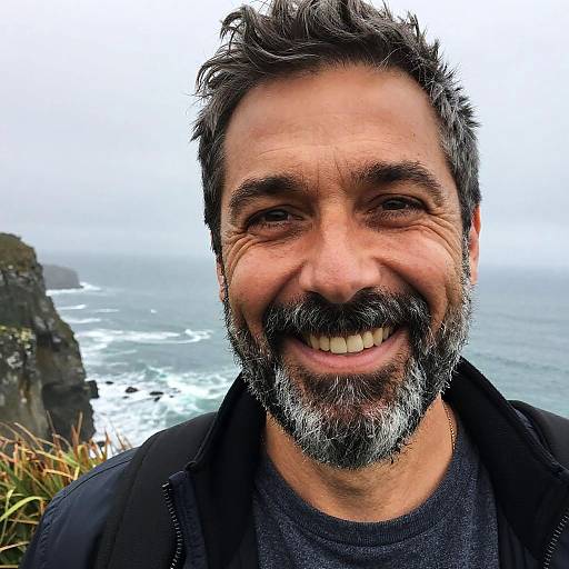 Smiling Middle-Aged Man by Foggy Ocean Cliff