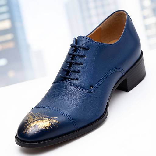 Photograph of a sleek, navy blue leather dress shoe with glossy finish, black laces, and a gold-accented toe cap, set against