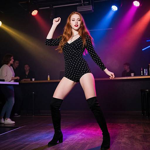 Photograph of a confident redhead woman in a black sparkly leotard and thigh-high boots, striking a powerful pose on a dimly lit stage