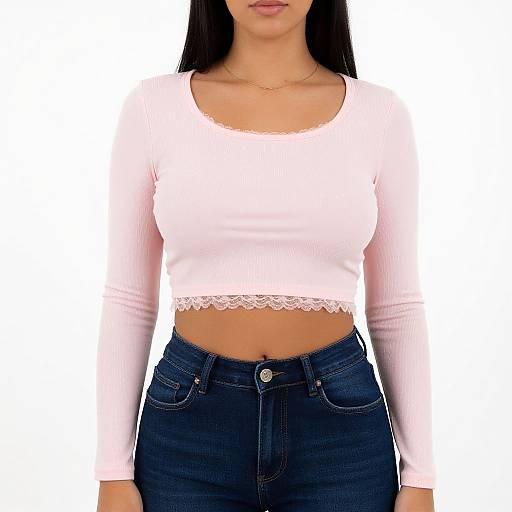 Photograph of a woman with long black hair, wearing a white long-sleeve crop top with lace trim and high-waisted blue jeans.