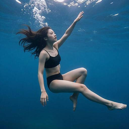 Woman Swimming Underwater in Black Bikini