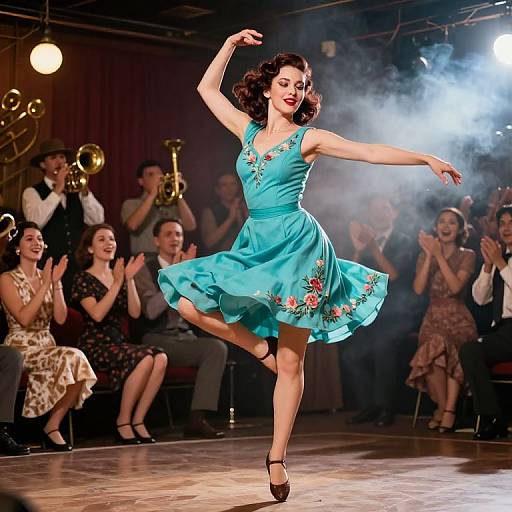 Photograph of a dancing woman in a turquoise, floral-embellished dress, mid-leap on stage, with an orchestra and clapping audience