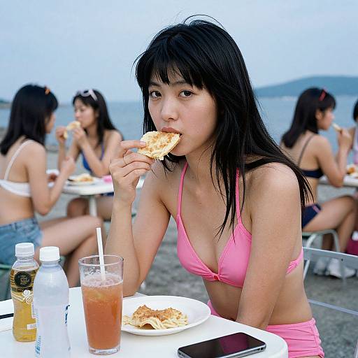 Photograph of an Asian woman with black hair, pink bikini, eating a sandwich at a beach, surrounded by other women in bikinis.