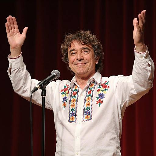 Smiling Man in Embroidered Shirt on Stage