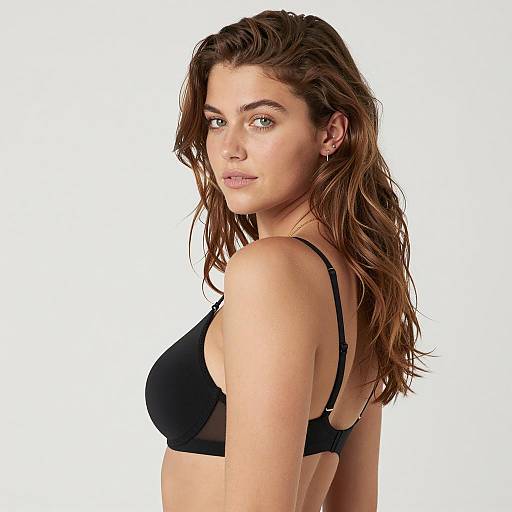 Young woman in black bra posing sideways