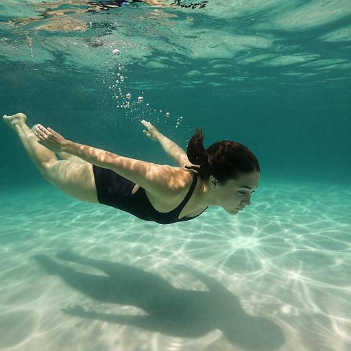 Woman Swimming Underwater in Black Swimsuit