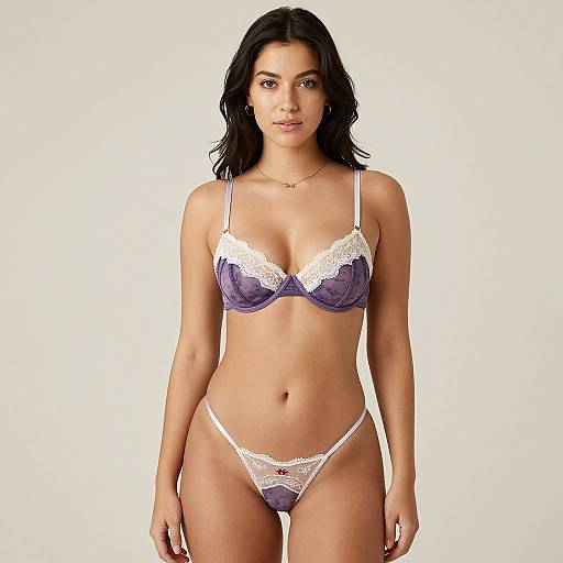 Photograph of a confident woman with medium skin tone, black wavy hair, wearing a purple and white lace bra and matching thong, standing against