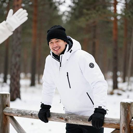 Smiling Man in Winter Jacket Leaning on Wooden Fence