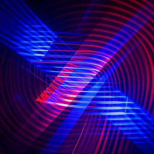 Abstract photograph of vibrant blue and red light trails creating dynamic, swirling patterns against a dark background, resembling a cosmic or energetic vortex.