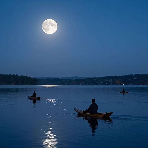 Photograph of three silhouetted kayakers on a calm, blue-lit lake at night, with a bright full moon reflecting on the water