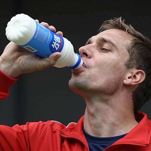 Man Drinking from Blue and White Milk Bottle