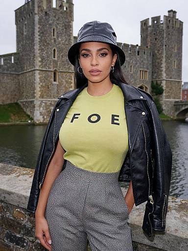 Photograph of a confident woman with dark skin, wearing a yellow 