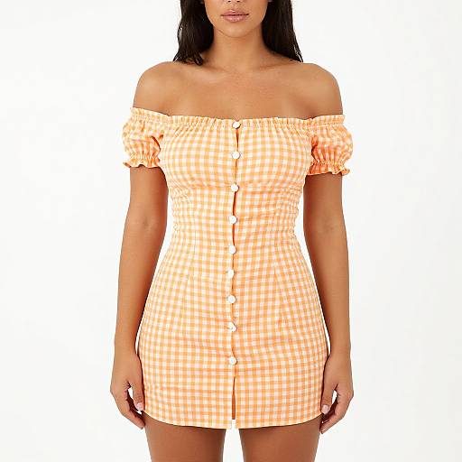 Photograph of a woman with tan skin wearing an off-shoulder, orange-and-white checkered dress with buttons down the front, against a plain