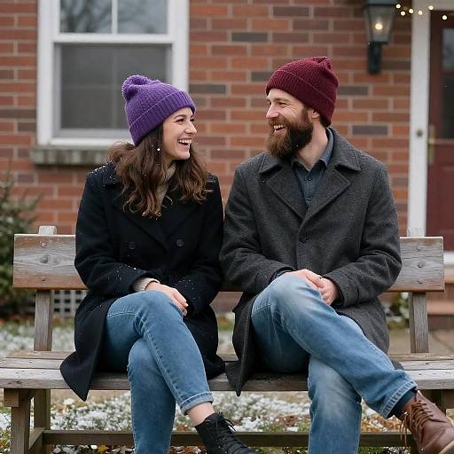 Couple Sitting on Bench in Winter Hats and Coats
