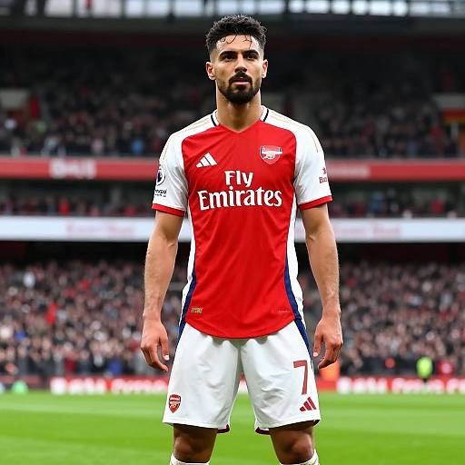 Photograph of a male soccer player with short curly black hair, beard, and medium build, wearing a red and white Arsenal jersey with 