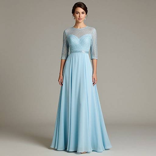 Photograph of a woman in a light blue, floor-length gown with lace sleeves and a fitted bodice, standing against a gray background.