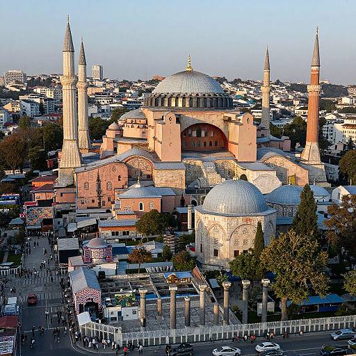Photograph of Istanbul's Hagia Sophia, showcasing its iconic domes and minarets, surrounded by densely packed buildings under a clear blue sky.
