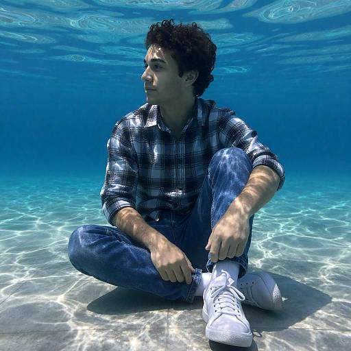 Young Man Sitting Underwater on Tiled Floor