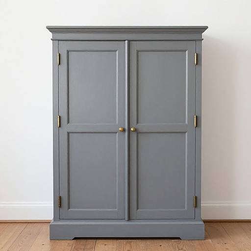 Photograph of a vintage-style, blue-gray wooden cabinet with brass knobs and gold hardware, standing on a wooden floor against a white wall.