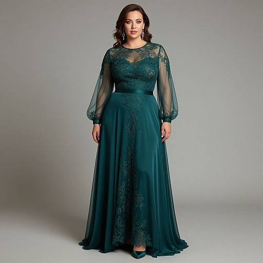 Photograph of a curvy woman with dark brown hair wearing a floor-length, teal lace and chiffon gown with sheer sleeves, standing against a plain
