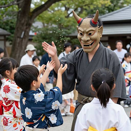 Photograph of a Japanese festival: A man in a traditional gray kimono and red-and-black horned mask, smiling and waving, interacts with children