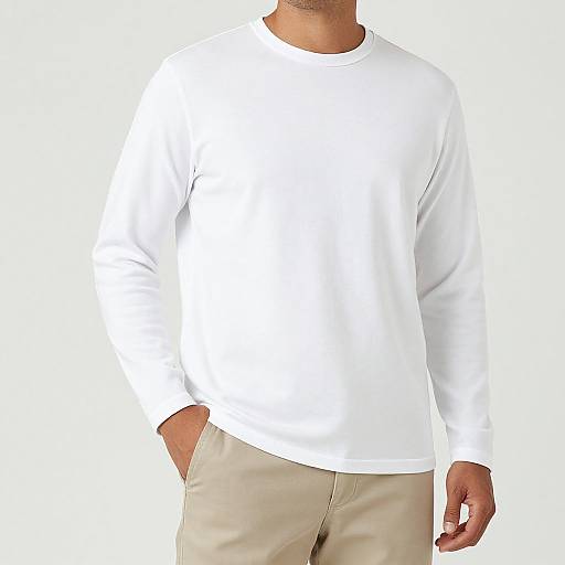 Photograph of a man wearing a plain white long-sleeve shirt and beige pants, with his right hand in his pocket, against a white background