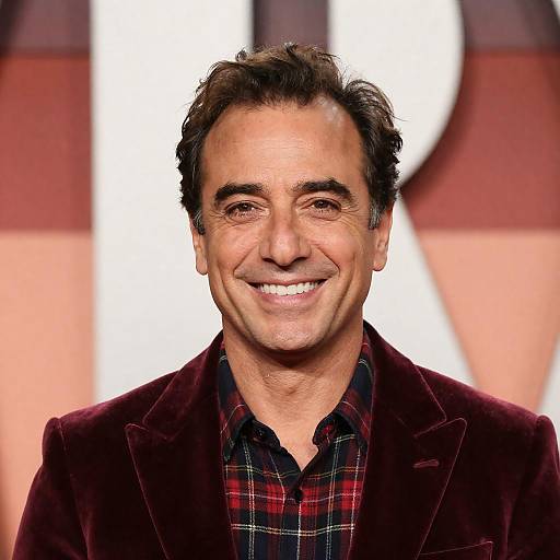 Middle-aged man in red velvet jacket smiling