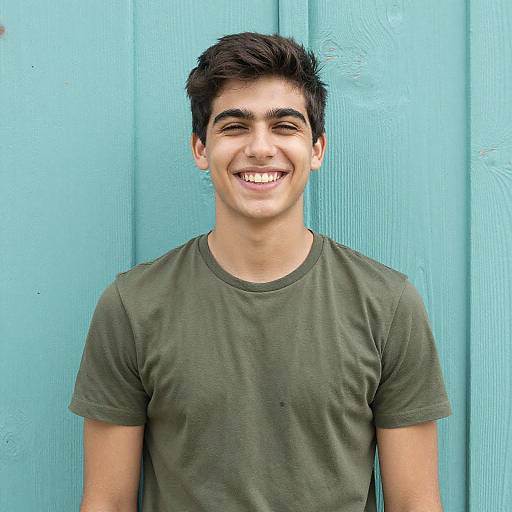 Smiling Young Man Against Turquoise Wooden Wall