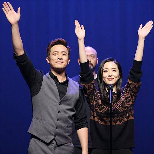 Man and Woman Waving on Stage