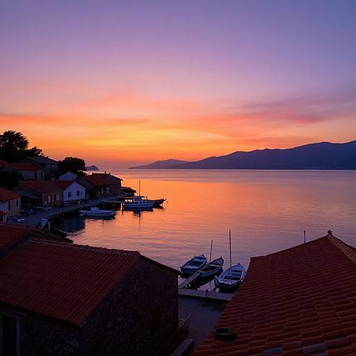 Photograph of a serene coastal sunset with vibrant orange, pink, and purple sky reflecting on calm water, surrounded by red-roofed houses and small