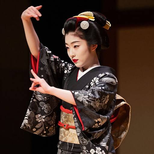 Photograph of an Asian woman in a black floral kimono with red obi, black hair styled with ornate hairpins, adjusting her hair,