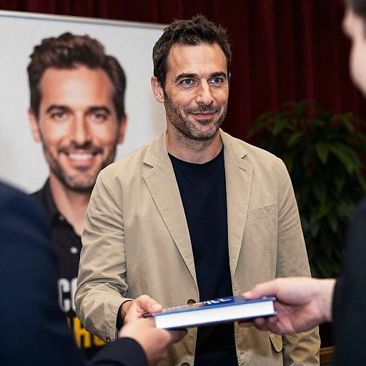Man Receiving Book at Indoor Event